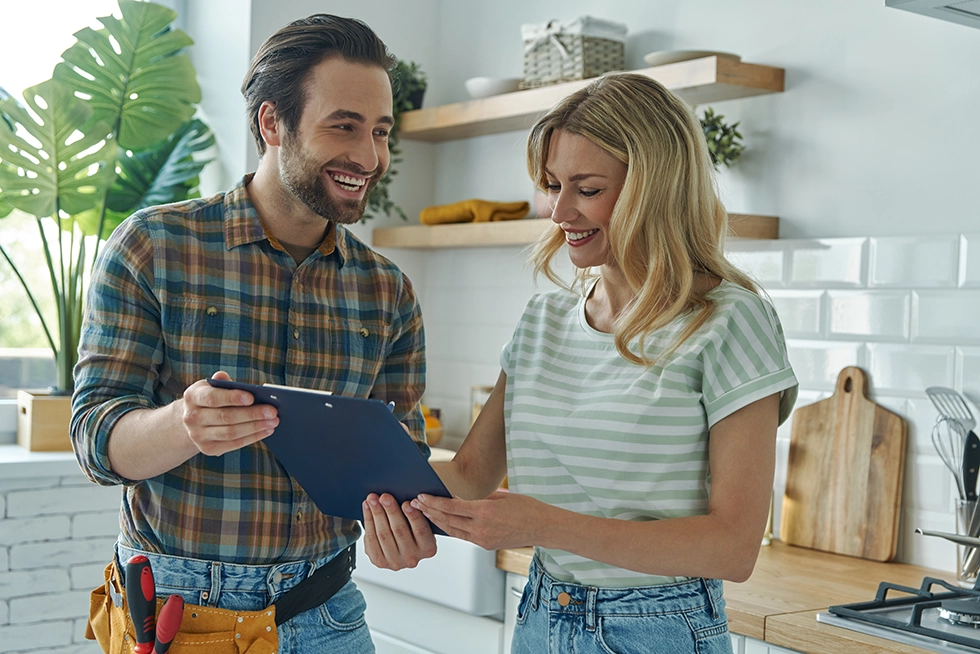 shutterstock_2164279745 Handwerker und Kundin in Küche stehend